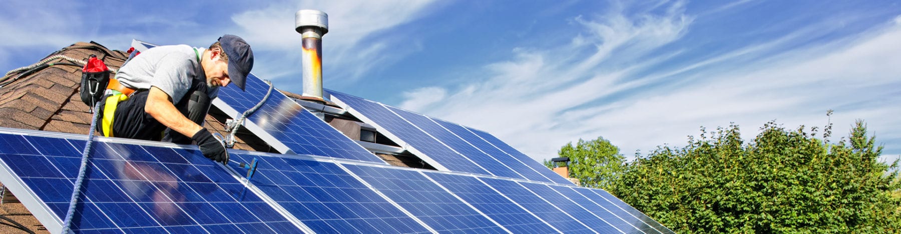 A residential solar systems tech installing panels on a home.