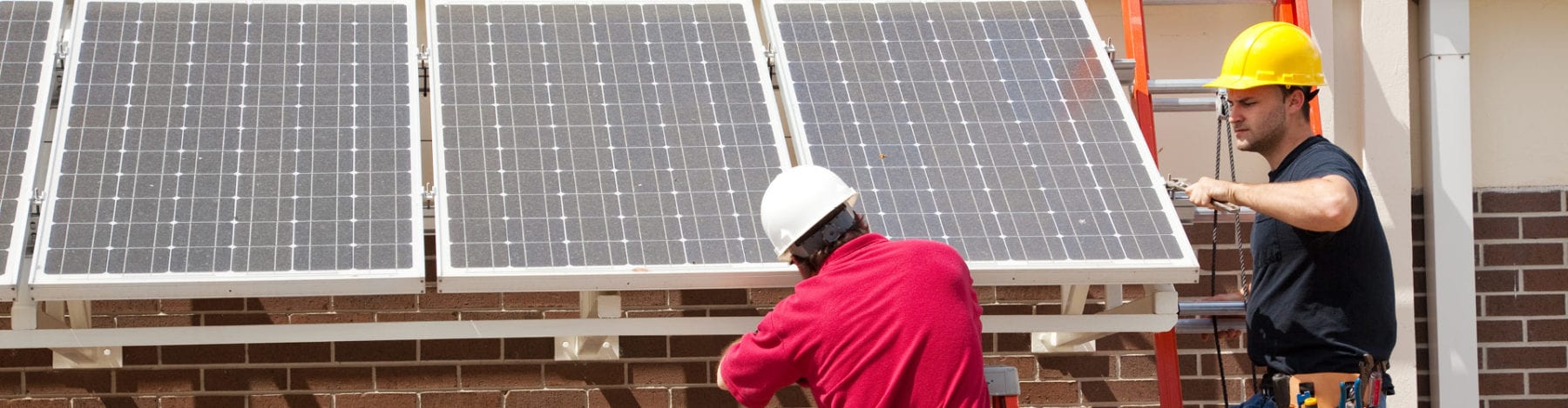 Two SunState Solar techs providing professional commercial solar energy systems installation services.